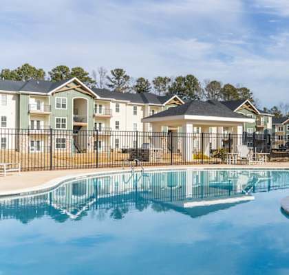 A swimming pool in front of a row of houses.