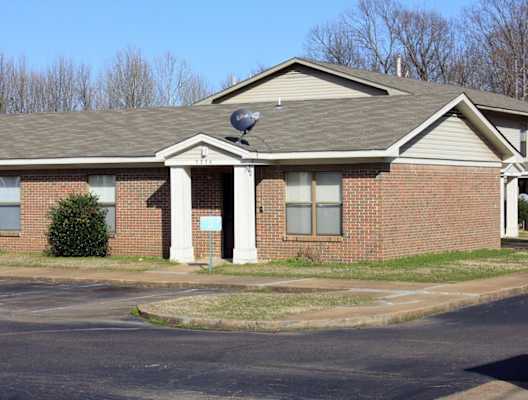 a brick house with a satellite dish on the roof