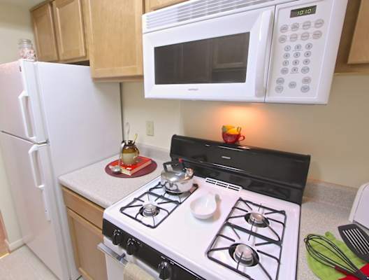 a small kitchen with a stove microwave and refrigerator
