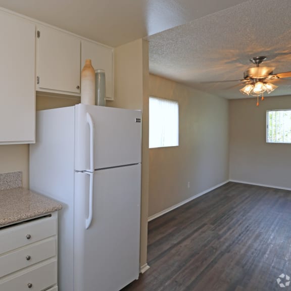 a kitchen with white cabinets and a white refrigerator