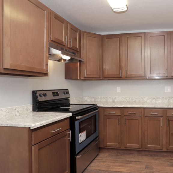 a kitchen with wooden cabinets and granite countertops