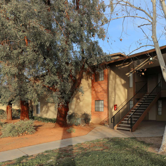 a building with a staircase and trees in front of it