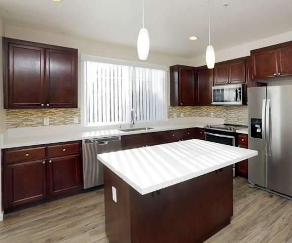 a kitchen with a large island and stainless steel appliances