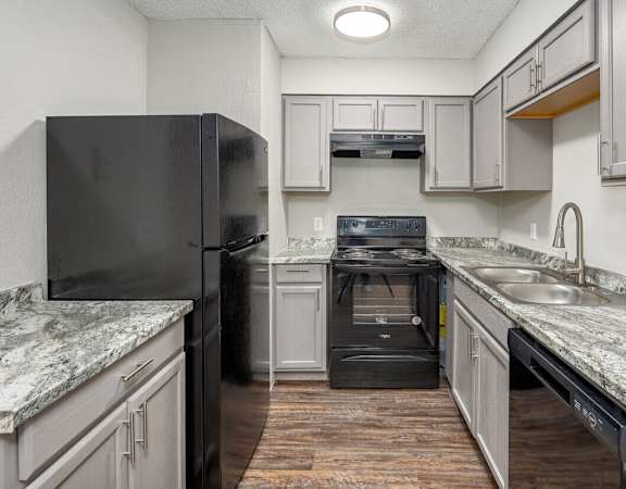 a kitchen with white cabinets and black appliances and granite counter tops