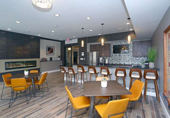 a dining room with tables and chairs and a kitchen