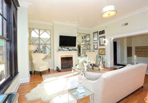 a living room with a white couch and a fireplace at York House, Saint Louis