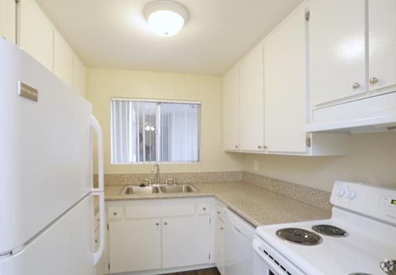 a kitchen with white appliances and white cabinets