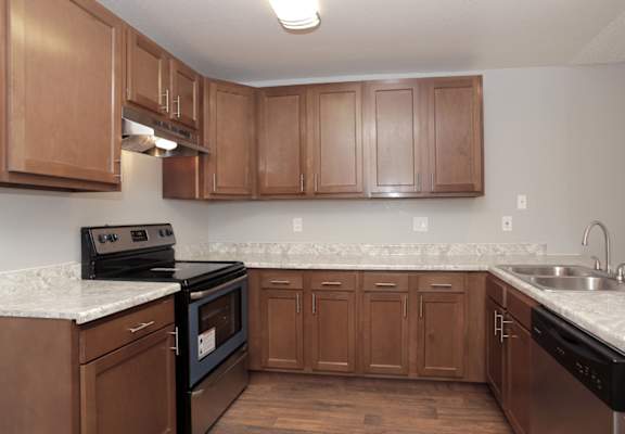 a kitchen with wooden cabinets and granite countertops