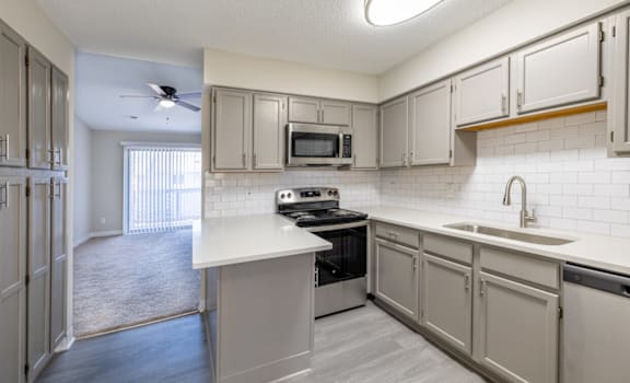 A kitchen with a white counter top and a black stove.