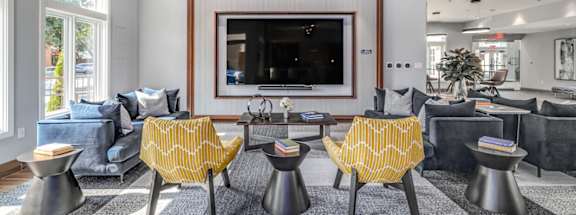 A living room with a television and yellow chairs.