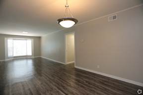 A room with a wooden floor and a light hanging from the ceiling.
