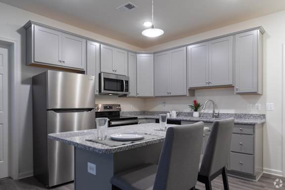 A kitchen with a table and chairs.