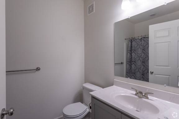 A white toilet sits next to a sink in a bathroom.