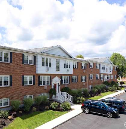 A row of townhouses with a car parked in front. at Kings Gate West Apartments, New York, 13031
