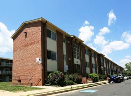 A red brick building with a white door and windows.