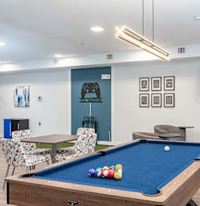 A pool table with a blue cloth and several balls on it.