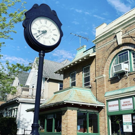 a clock on a pole in front of a building at The Collings at the Lumberyard, Collingswood, 08108