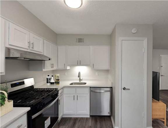 an empty kitchen with white cabinets and a black stove and