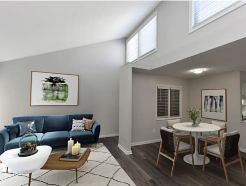 a living room with a blue couch and a dining room table