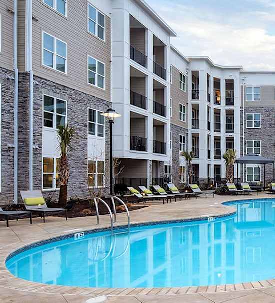 a swimming pool with an apartment building in the background