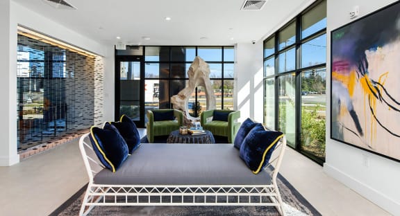 a large living room with a blue couch and white chairs