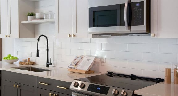 Sophisticated white countertops with subway tile backsplash and dark cabinets at Novel Cary