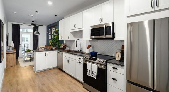 Elegant kitchen with tile backsplash, white cabinets, and dark countertops at Novel Harpeth Heights