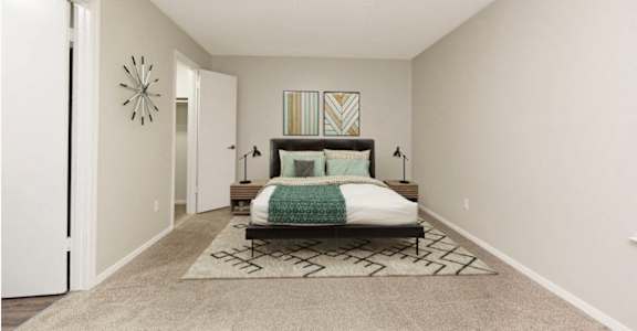 a bedroom with a bed and a door to a closet
