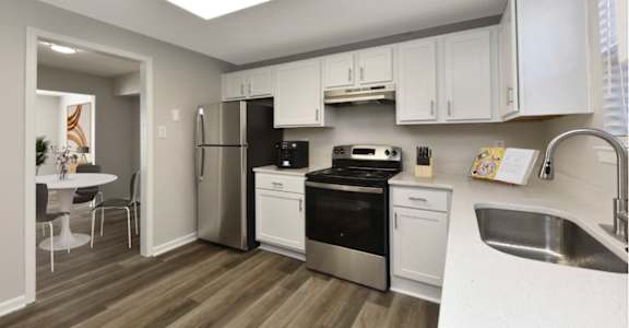 a kitchen with white cabinets and stainless steel appliances