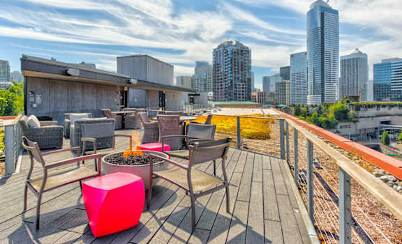 a rooftop deck with a fire pit and a view of the minneapolis skyline