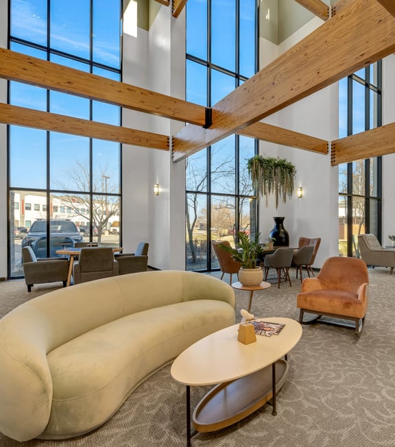 a large living room with large windows and a beige couch
