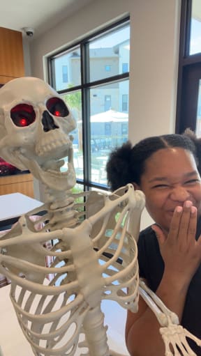 a woman with her face next to a skeleton