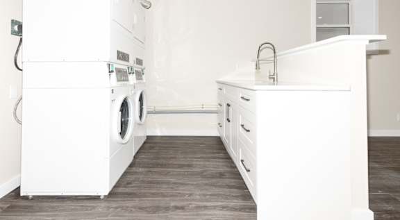 A white laundry room with a washer and dryer.