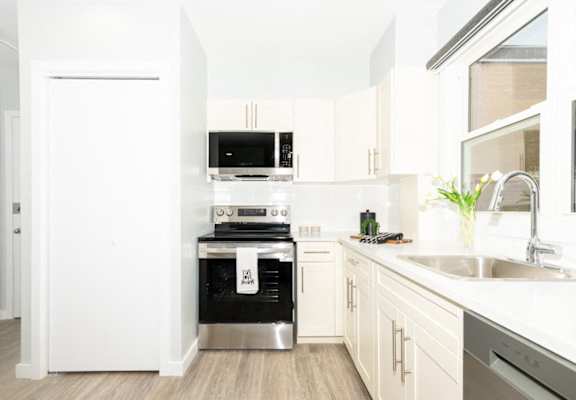 A modern kitchen with white appliances and wooden cabinets.