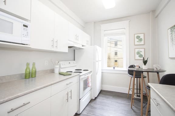 a kitchen with white cabinets and a window