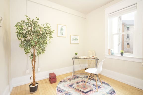 a living room with a tree and a desk with a chair