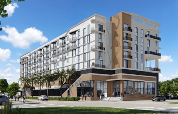A modern multi-story building with balconies and large windows.