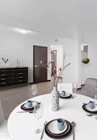 A modern dining room with a white table set for four.