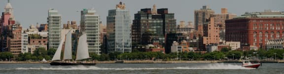a sailboat on the water in front of the city skyline at The Enclave, Jersey City, New Jersey