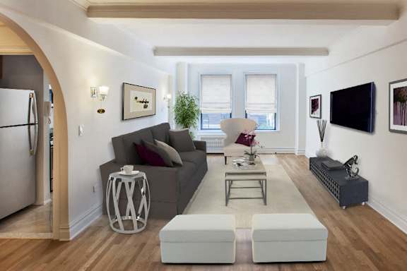 A modern living room with a grey couch and a white coffee table.at Sutton Collection, New York, 10022