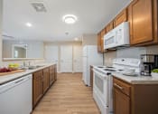 Thumbnail 56 of 58 - A kitchen with white appliances and wooden cabinets.