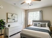 Thumbnail 25 of 28 - A bedroom with a large bed and a ceiling fan.