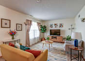 Thumbnail 23 of 27 - A living room with a yellow sofa and a wooden coffee table.