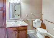 Thumbnail 27 of 28 - A white toilet is in a bathroom with a sink and mirror.