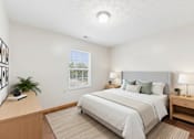 Thumbnail 62 of 64 - A bedroom with a large bed, a nightstand, and a window with blinds.
