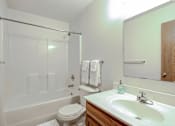 Thumbnail 28 of 28 - A white toilet sits next to a white bathtub in a bathroom.