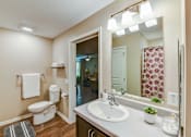 Thumbnail 56 of 56 - A bathroom with a toilet, sink, and mirror.