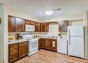 Thumbnail 55 of 56 - A kitchen with wooden cabinets and white appliances.