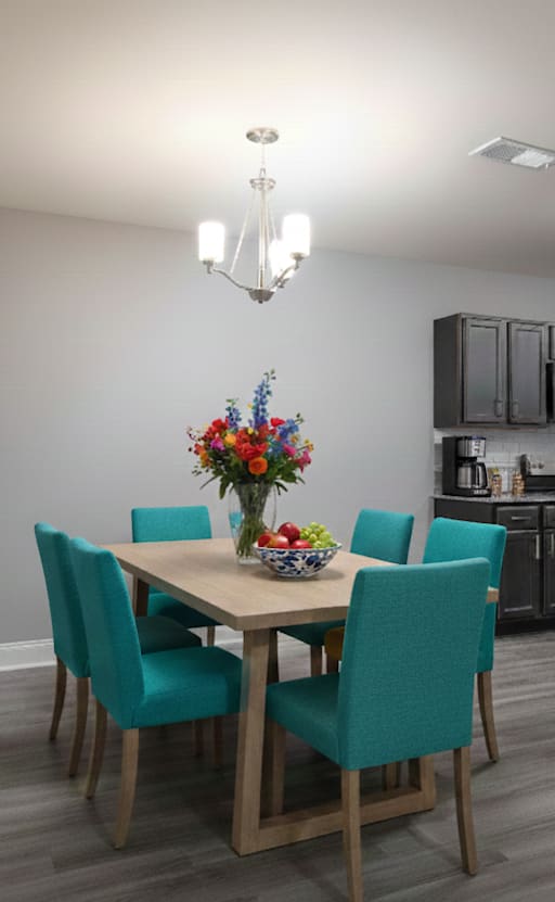 A room with a round wooden table and chairs.