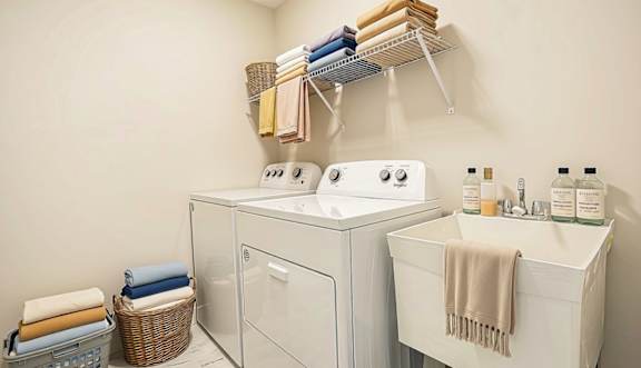 A white washing machine and sink in a small laundry room.